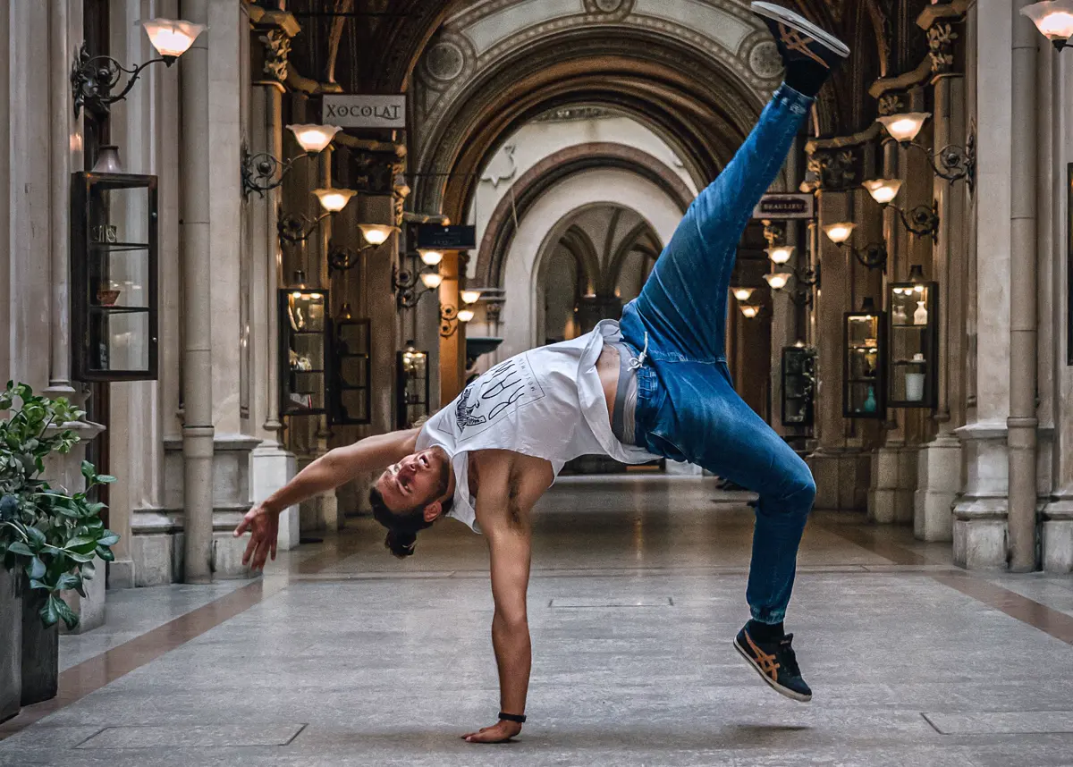 Acrobatic floor move in a historic arcade in Vienna