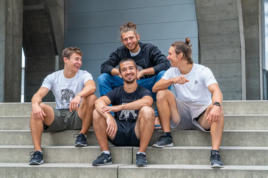 The RAW Movement coaching team sitting and laughing on concrete steps